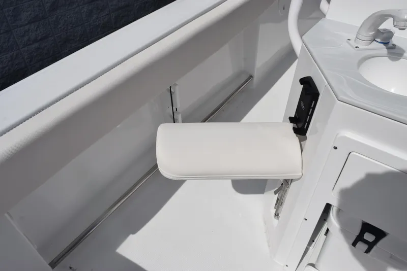Slide: The Image of 2026 Sea Hunt Ultra 245 SE boat interior with white cushioned seat and sink. - 19
