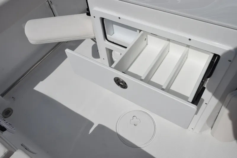 Slide: The Image of 2026 Sea Hunt Ultra 245 SE boat storage compartment with open drawer and dividers. - 20
