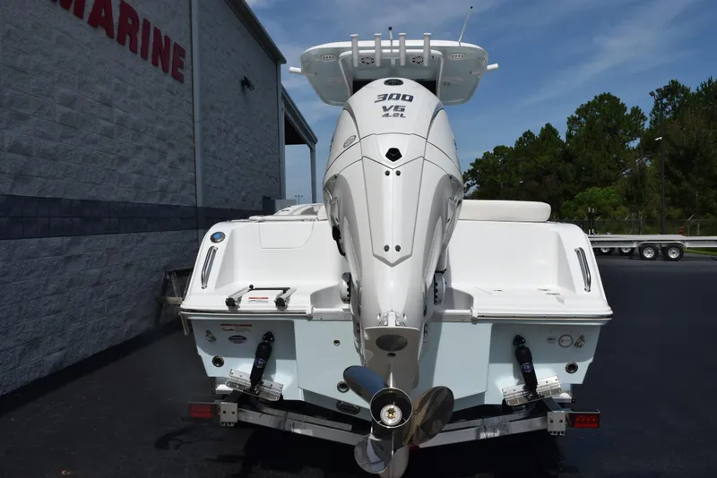 Slide: The Image of 2026 Sea Hunt Ultra 245 SE boat with powerful outboard motor, parked near a marine facility. - 5