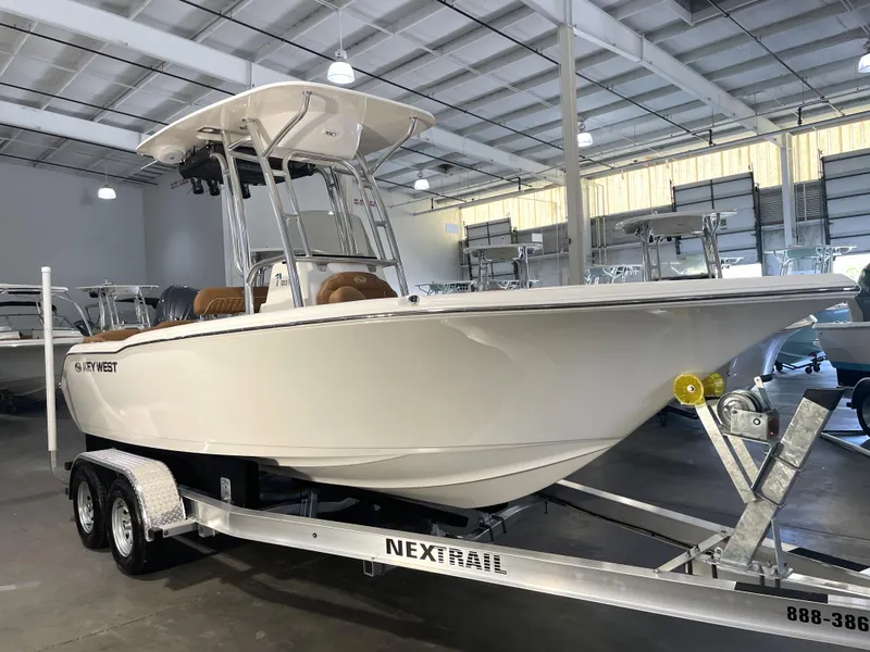 The Image of 2025 Key West 203 FS boat on trailer in showroom, featuring sleek design and modern amenities. - 0