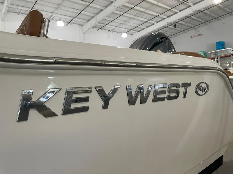 Slide: The Image of 2025 Key West 203 FS boat in showroom, featuring sleek design and chrome lettering. - 15