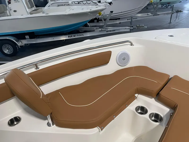 Slide: The Image of 2025 Key West 203 FS boat interior with brown cushioned seating and cup holders. - 19