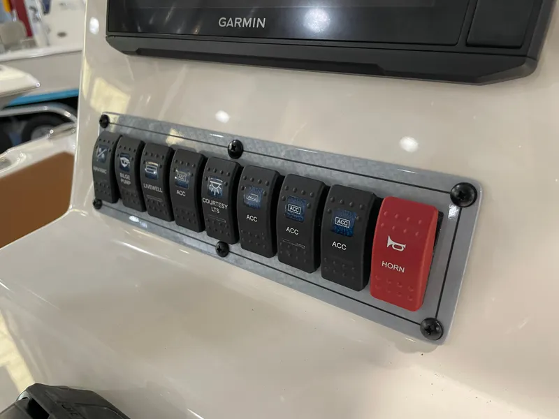 Slide: The Image of Control panel of 2025 Key West 203 FS boat with labeled switches and Garmin display. - 28