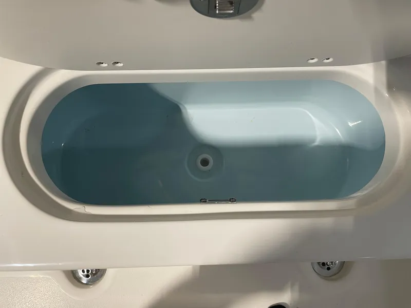 Slide: The Image of 2025 Key West 203 FS boat interior, featuring a clean, white and blue storage compartment. - 37