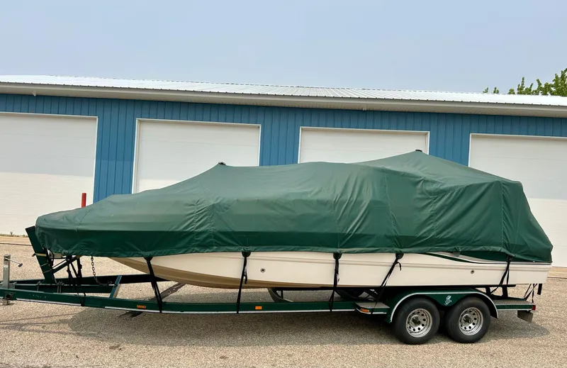 Slide: The Image of 2000 Chaparral Sunesta 233 boat on trailer, parked in front of blue garage doors. - 1