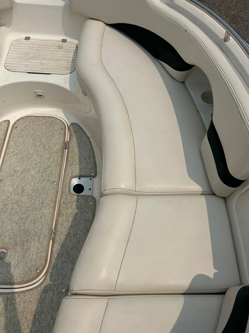 Slide: The Image of 2000 Chaparral Sunesta 233 boat interior with white and blue cushioned seating. - 11