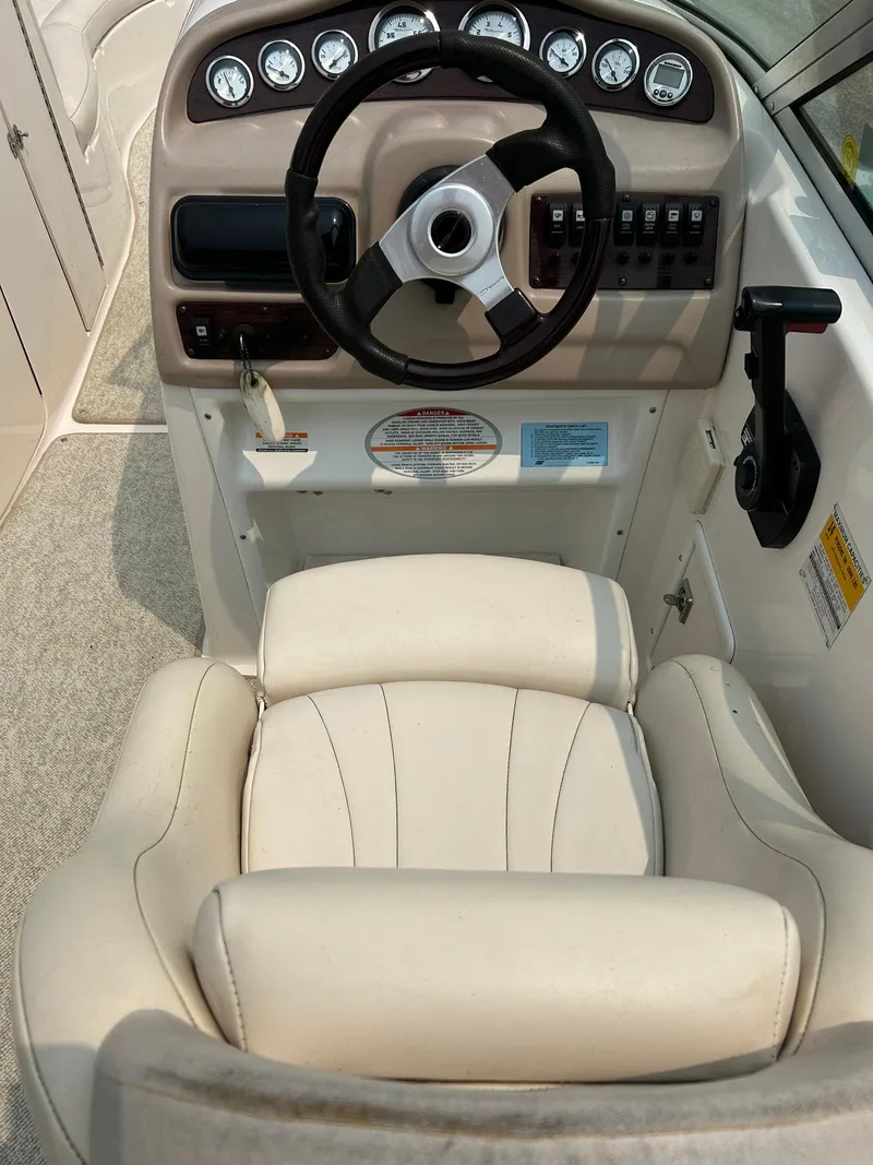 Slide: The Image of 2000 Chaparral Sunesta 233 boat on trailer, parked outside blue building. - 21