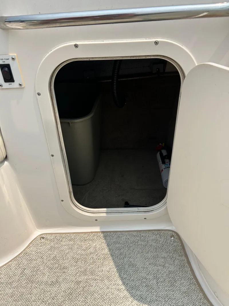 Slide: The Image of Storage compartment in 2000 Chaparral Sunesta 233 boat, featuring white and blue upholstery. - 41