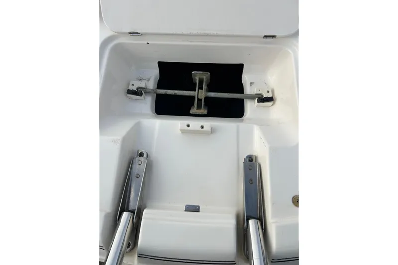 Slide: The Image of 2000 Chaparral Sunesta 233 boat compartment with metal fittings and white interior. - 46