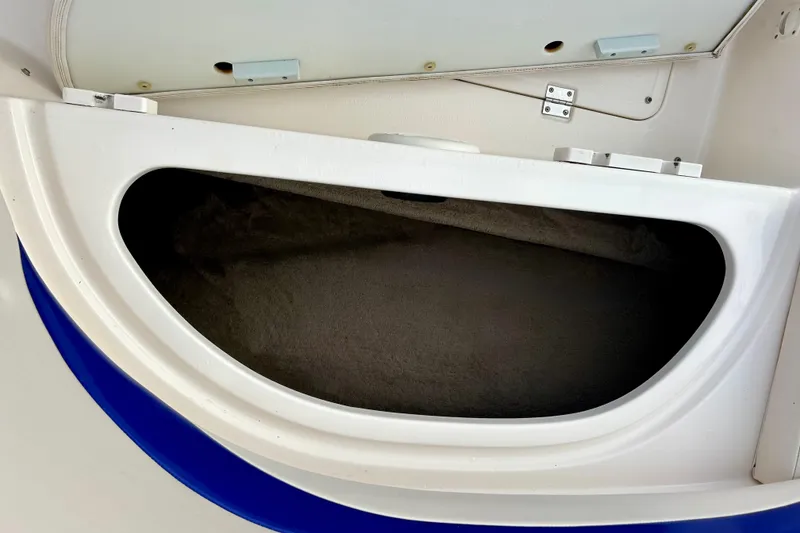 Slide: The Image of Storage compartment in a 2000 Chaparral Sunesta 233 boat, featuring a white and blue design. - 49