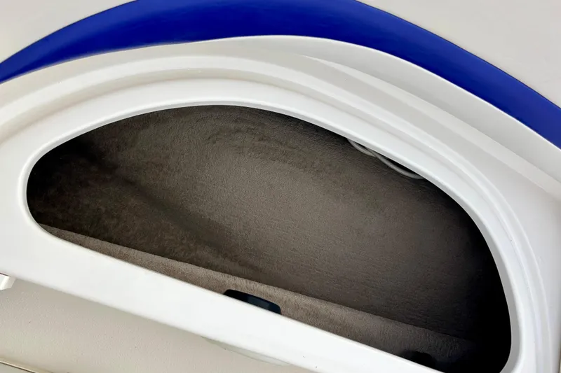 Slide: The Image of Storage compartment in 2000 Chaparral Sunesta 233 boat, featuring white and blue trim. - 51