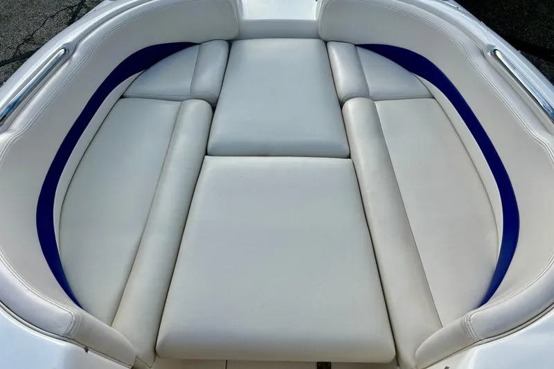 Slide: The Image of 2000 Chaparral Sunesta 233 boat interior with white and blue cushioned seating. - 63