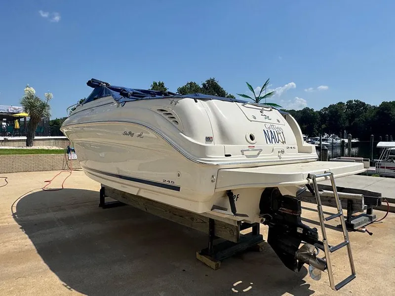 Slide: The Image of 2001 Sea Ray 245 Weekender boat on dry dock under clear blue sky. - 1
