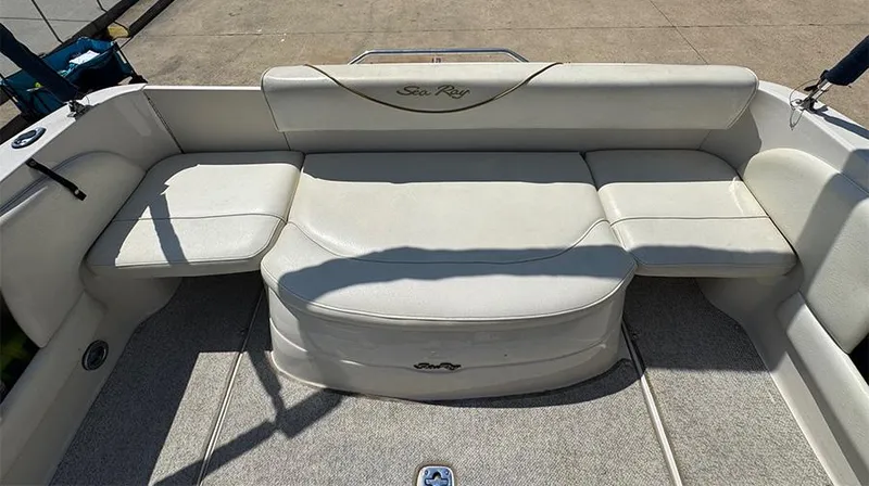 Slide: The Image of 2001 Sea Ray 245 Weekender boat interior with white seating and carpeted floor. - 11