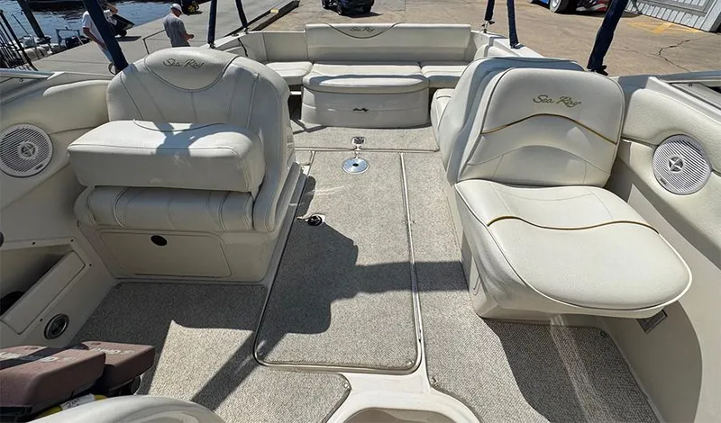 Slide: The Image of 2001 Sea Ray 245 Weekender boat interior with white seating and carpeted floor. - 12