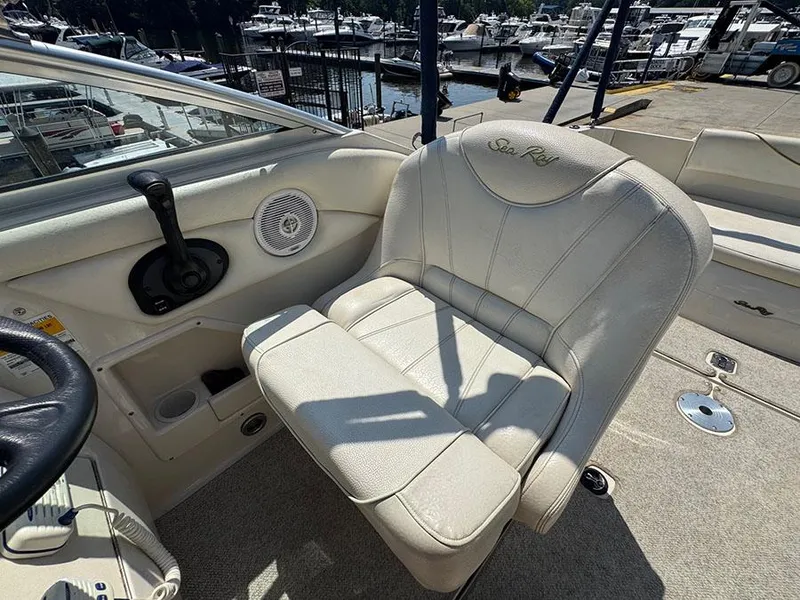 Slide: The Image of 2001 Sea Ray 245 Weekender boat interior with helm seat and marina view. - 14