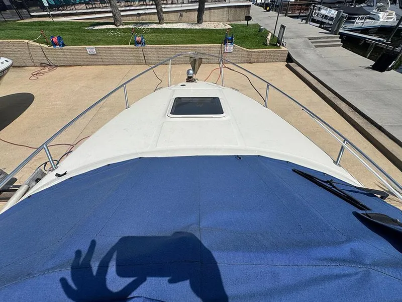Slide: The Image of 2001 Sea Ray 245 Weekender boat docked, view from bow with blue cover. - 15