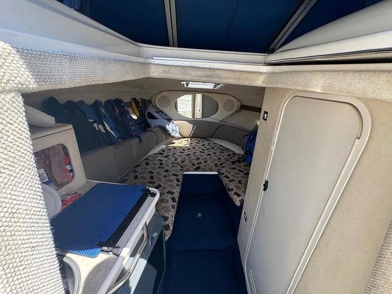 Slide: The Image of Interior of 2001 Sea Ray 245 Weekender boat, featuring cozy cabin and seating area. - 17