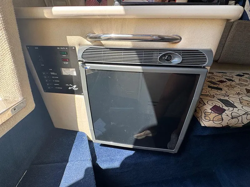 Slide: The Image of 2001 Sea Ray 245 Weekender interior with mini fridge and control panel. - 18