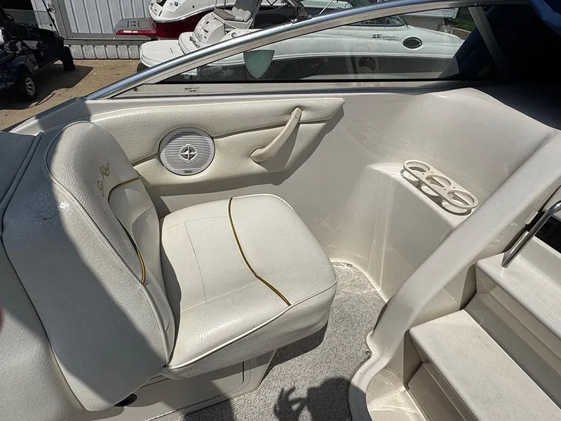 Slide: The Image of 2001 Sea Ray 245 Weekender boat interior with white seating and cup holders. - 24