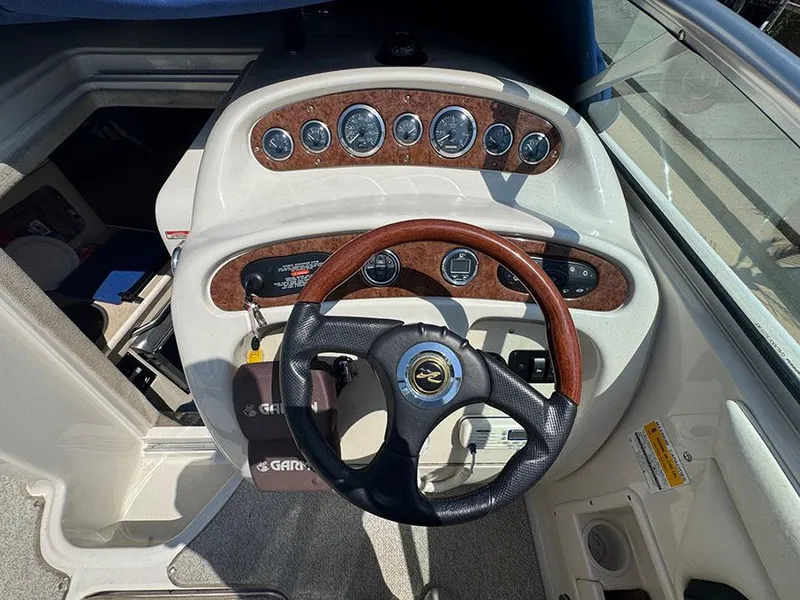 Slide: The Image of 2001 Sea Ray 245 Weekender boat dashboard with wood accents and steering wheel. - 6