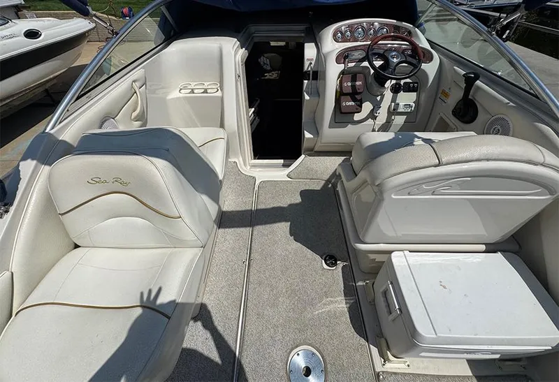 Slide: The Image of 2001 Sea Ray 245 Weekender boat interior with seating and helm controls. - 7