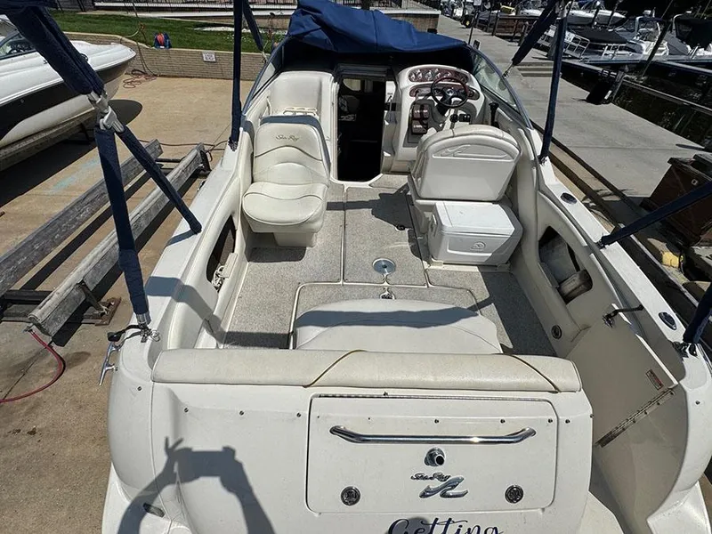 Slide: The Image of 2001 Sea Ray 245 Weekender boat interior with seating and helm, docked at marina. - 9