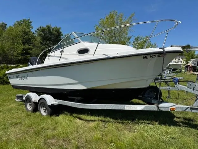 The Image of 2005 Boston Whaler 205 Eastport boat on trailer, parked on grass. - 1