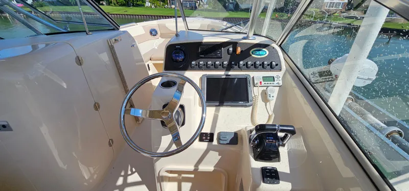 Slide: The Image of 2014 Grady-White Freedom 285 boat dashboard with steering wheel and navigation controls. - 16