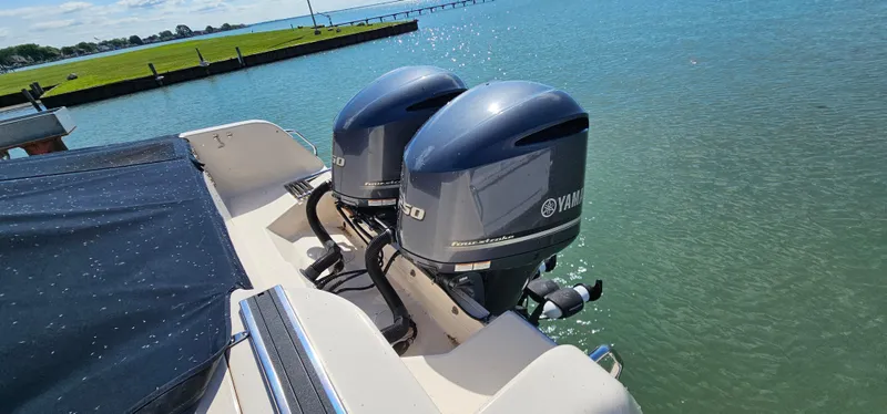 Slide: The Image of 2014 Grady-White Freedom 285 boat docked on a lift by the water. - 2