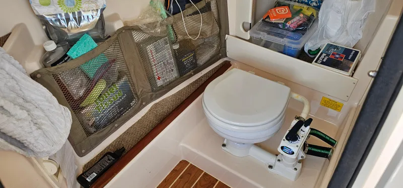 Slide: The Image of 2014 Grady-White Freedom 285 boat interior with dual engines, docked by the water. - 20