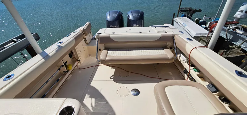 Slide: The Image of 2014 Grady-White Freedom 285 boat interior with twin 250 engines, docked by the water. - 21
