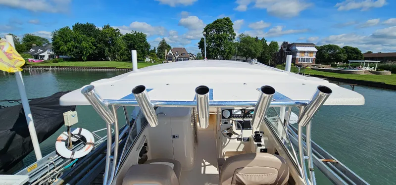 Slide: The Image of 2014 Grady-White Freedom 285 boat interior with beige seating, docked by calm waters. - 24