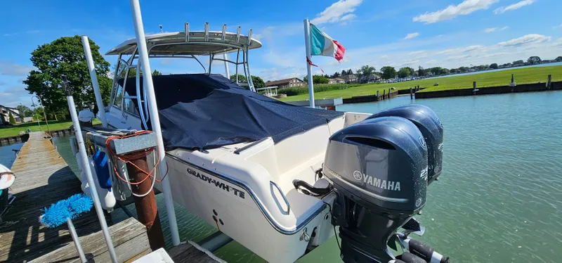 Slide: The Image of Twin Yamaha 250 engines on a 2014 Grady-White Freedom 285 boat, docked by the water. - 26