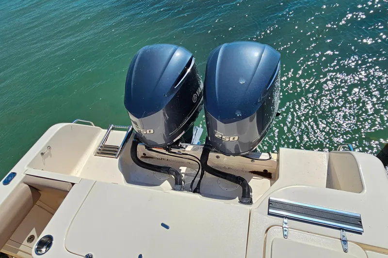 Slide: The Image of 2014 Grady-White Freedom 285 boat with T-top and rod holders, docked under clear blue sky. - 28