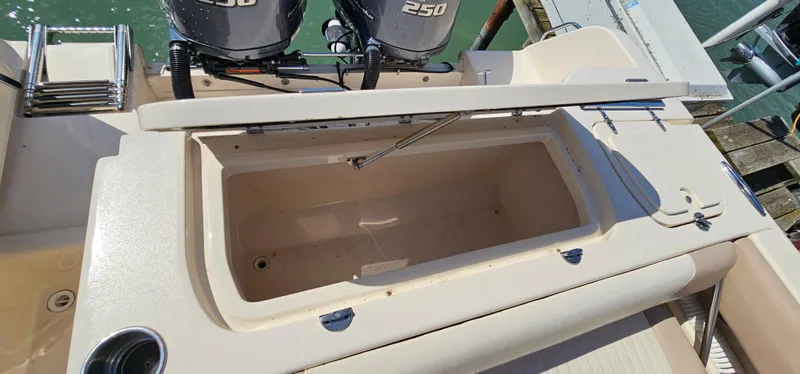 Slide: The Image of 2014 Grady-White Freedom 285 boat interior with seating and steering wheel, docked by water. - 7