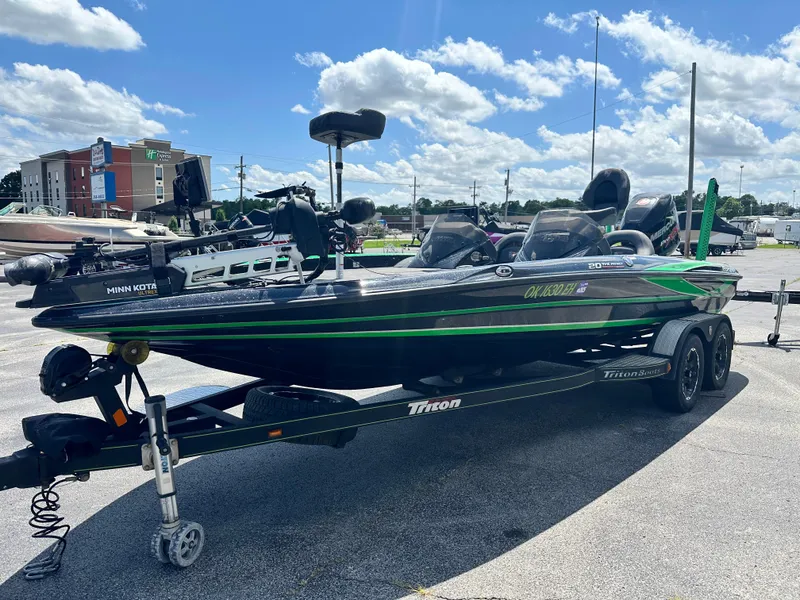 Slide: The Image of 2020 Triton 20 TRX Patriot bass boat on trailer, parked outdoors under a blue sky. - 4