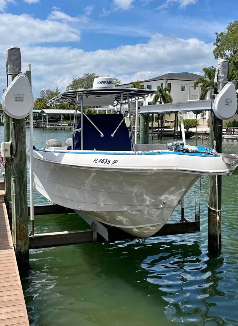 The Image of 1996 Pro-Line 27 CC boat on lift, docked in sunny marina setting. - 1