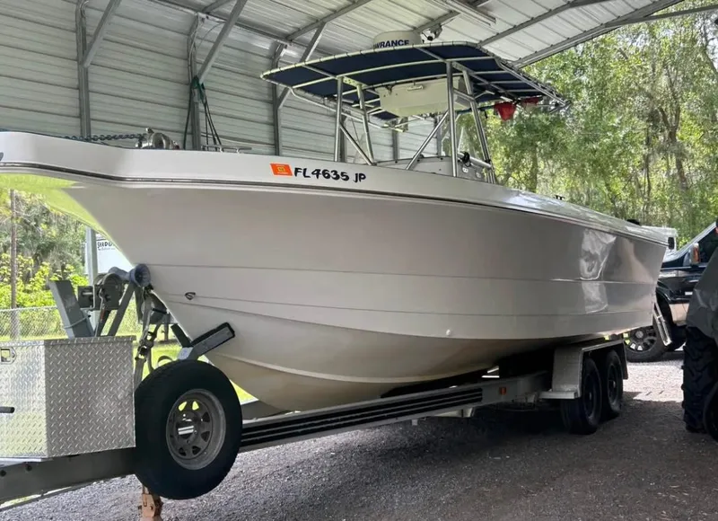 Slide: The Image of 1996 Pro-Line 27 CC boat on trailer under metal shelter. - 12