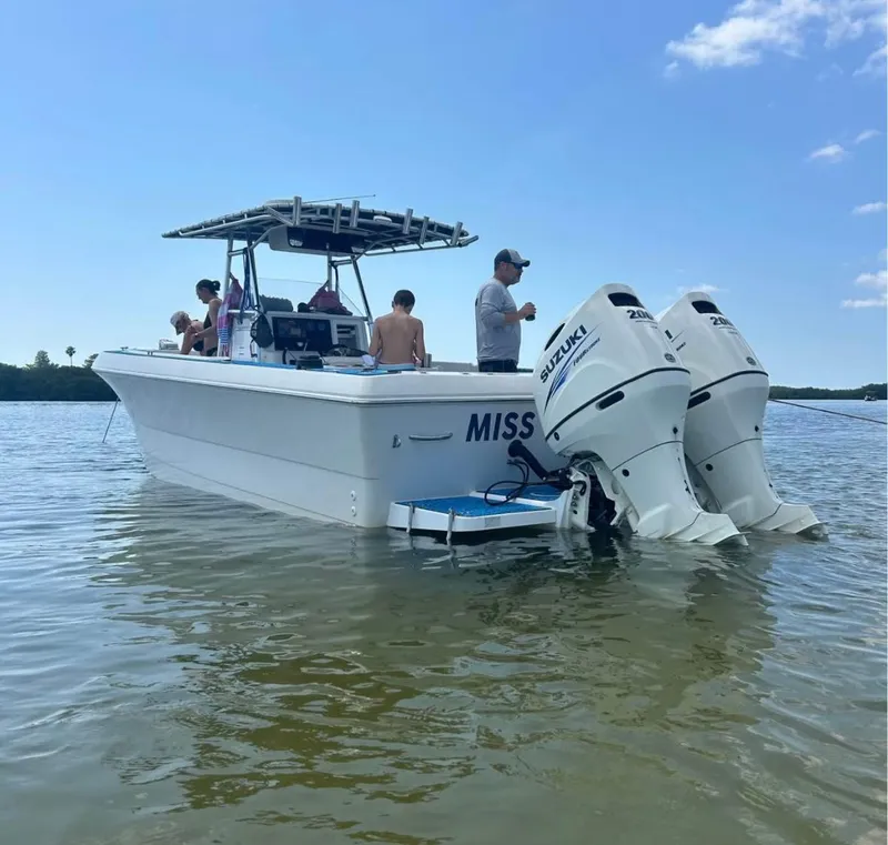 Slide: The Image of 1996 Pro-Line 27 CC boat with Suzuki engines, people enjoying a sunny day on the water. - 3
