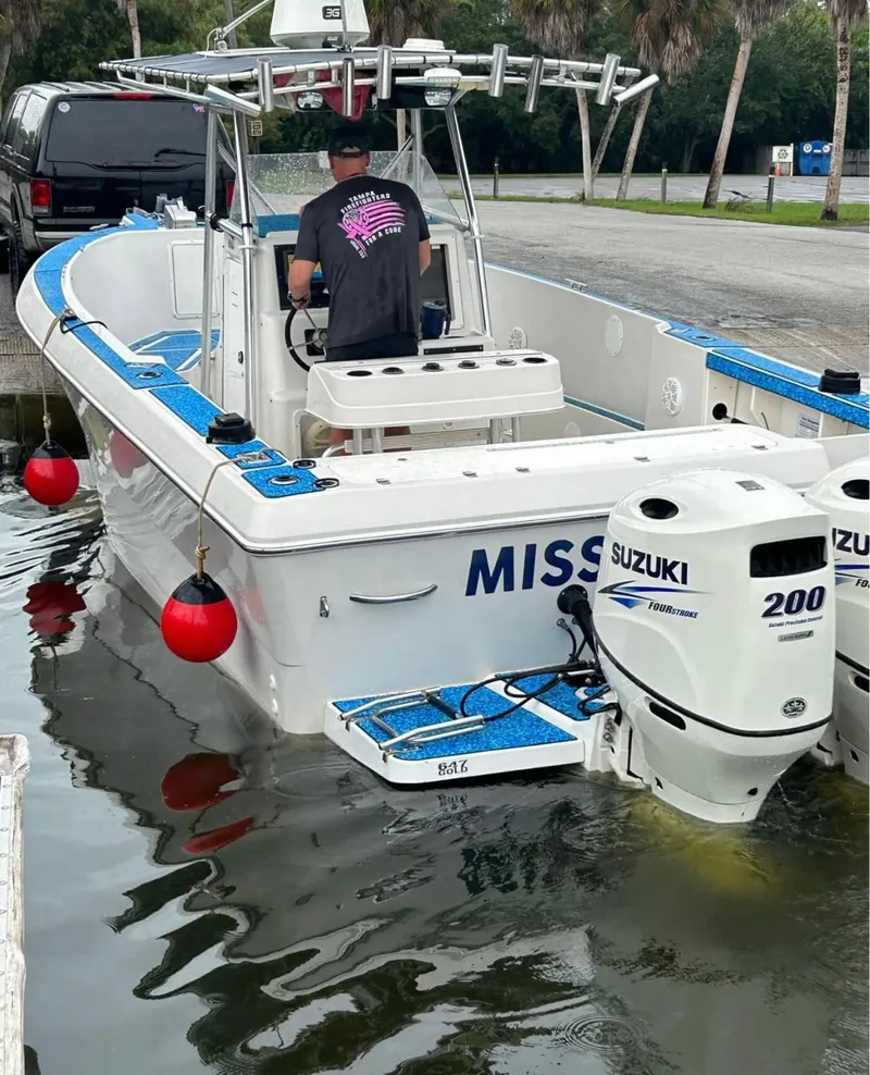 Slide: The Image of 1996 Pro-Line 27 CC boat with Suzuki engines docked, featuring blue accents and red buoys. - 5