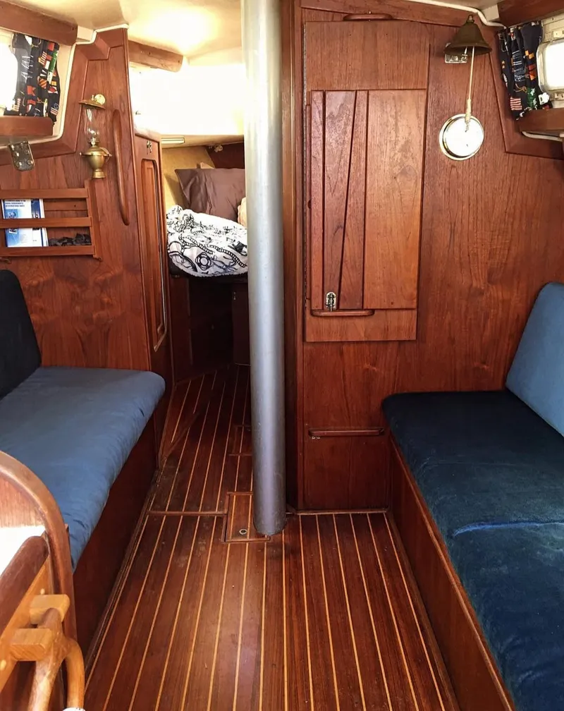 Slide: The Image of 1982 Morgan 32 sailboat interior with wooden finish and blue seating. - 2