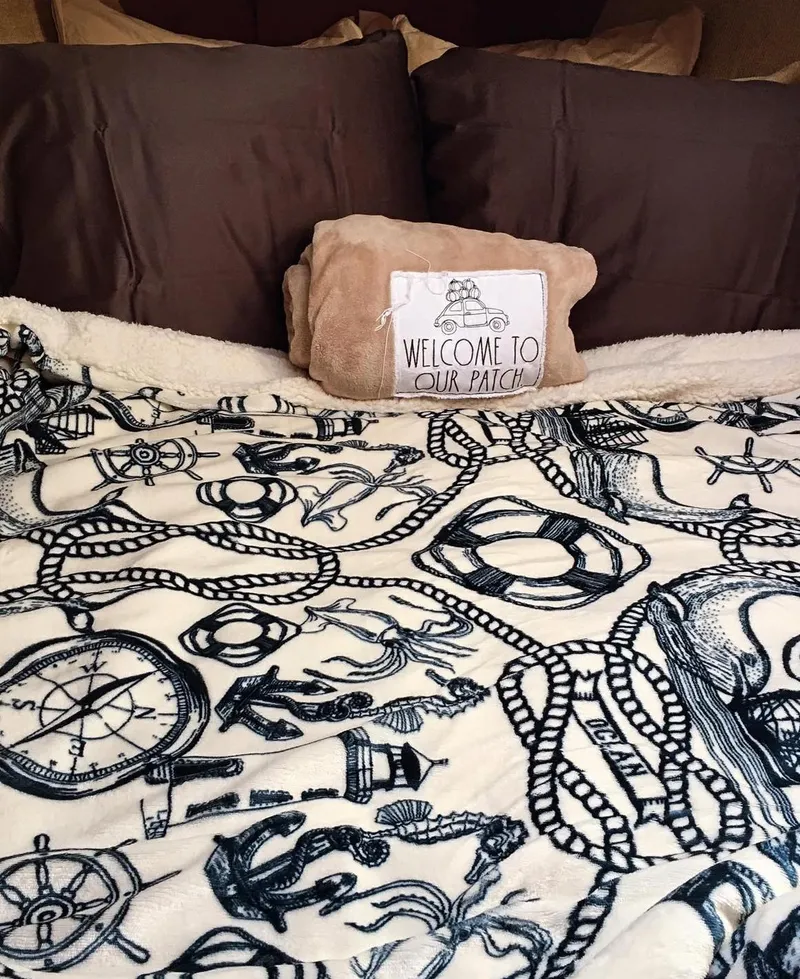 Slide: The Image of Cozy nautical-themed bedding with "Welcome to Our Patch" pillow on a Morgan 32, 1982. - 5