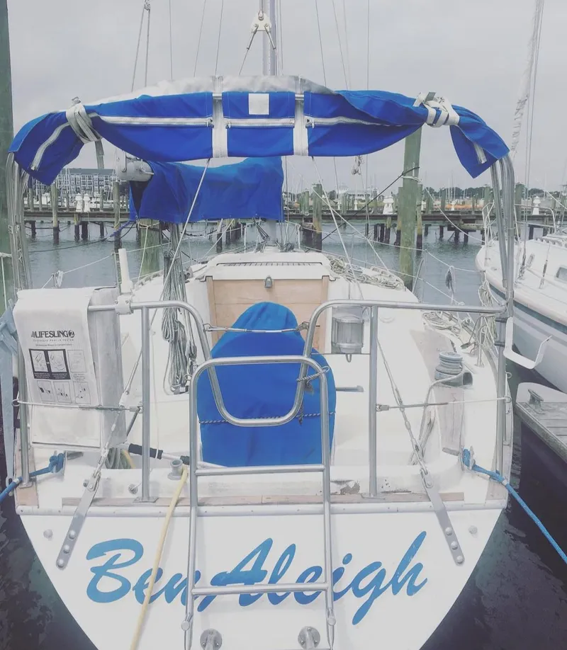 Slide: The Image of 1982 Morgan 32 sailboat docked, featuring blue canopy and "Ben Aleigh" name on stern. - 6