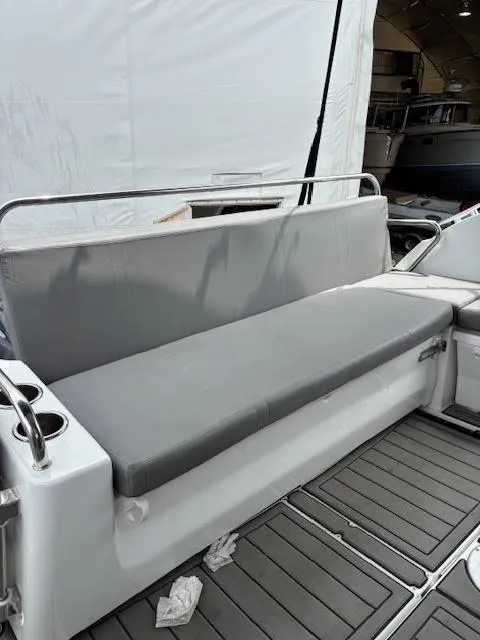 Slide: The Image of 2019 Beneteau Antares 27 boat seating area with gray cushions and cup holders. - 12