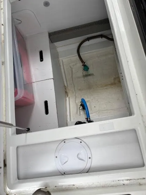 Slide: The Image of Storage compartment of a 2019 Beneteau Antares 27 boat, featuring hoses and containers. - 13
