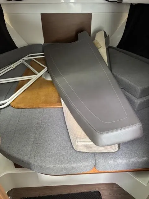 Slide: The Image of Interior of 2019 Beneteau Antares 27 with gray cushions and folded table. - 28