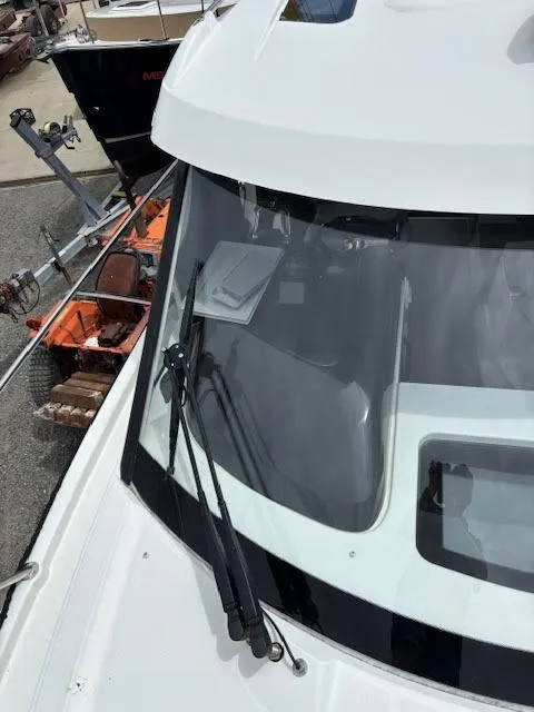 Slide: The Image of 2019 Beneteau Antares 27 boat windshield with wipers, docked near equipment. - 42