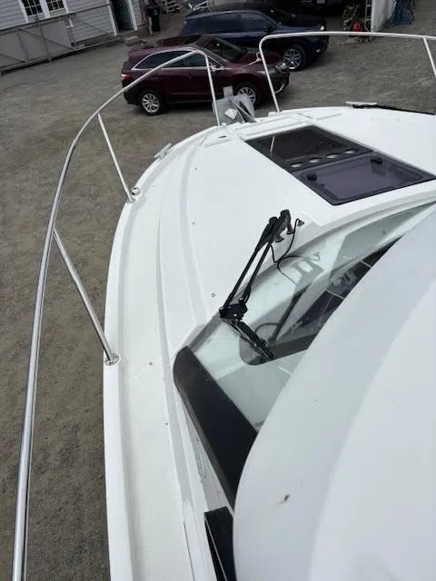 Slide: The Image of 2019 Beneteau Antares 27 boat deck with windshield, parked cars in background. - 43