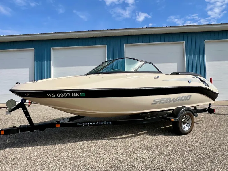 Slide: The Image of 2007 Sea-Doo 205 Utopia boat on trailer, parked outside blue building. - 6